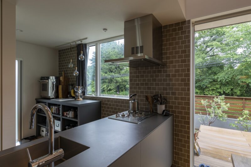 大きな窓からの風景とマッチしたグレーとブラウンのキッチン